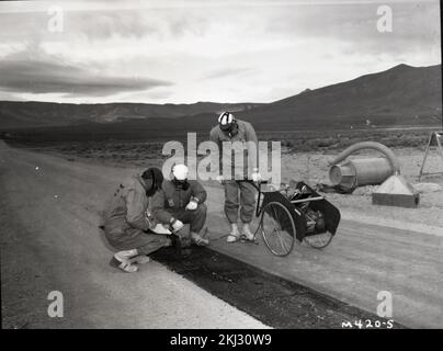 Progetto 40-11 - attività di test di Operation Buster/Jangle (Nevada Test Site). Progetto 6,2, uomini che misurano le intensità di radiazione su asfalto. Fotografie di Atmospheric Nuclear Testing a Pacific Island e Nevada Test Sites. Foto Stock
