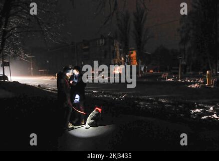 Kiev, Ucraina. 23rd Nov 2022. La gente usa la luce del telefono su una strada buia in Kyiv. Il 23 novembre, le truppe russe hanno sferrato un altro massiccio attacco missilistico, che ha portato a un'interruzione di corrente in tutta l'Ucraina. I missili colpiscono edifici residenziali e infrastrutture energetiche a Kiev e in molte regioni dell'Ucraina. (Credit Image: © Sergei Chuzavkov/SOPA Images via ZUMA Press Wire) Foto Stock