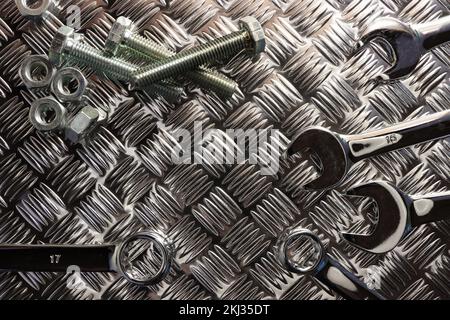 Chiavi con dadi e bulloni in acciaio sulla piastra antisdrucciolo Foto Stock