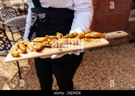 Ricevimento di nozze, catering per feste con antipasti e tartine serviti da camerieri in giardino per i loro ospiti Foto Stock