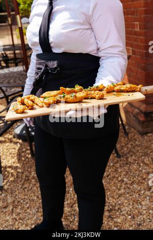 Ricevimento di nozze, catering per feste con antipasti e tartine serviti da camerieri in giardino per i loro ospiti Foto Stock