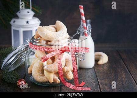 Biscotti di Natale crescents. Biscotti di Natale tradizionali fatti in casa crescentes di shortbread in vaso cosparso di zucchero a velo su vecchio sfondo di legno Foto Stock