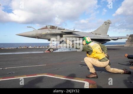 USS George HW Bush, Italia. 23rd Nov 2022. STATI UNITI Navy deck shooter segnala a un jet da combattimento francese della Marina Dassault Rafale il lancio dal ponte di volo della portaerei di classe Nimitz USS George H.W. Bush durante le operazioni multi-carrier, 23 novembre 2022 nel Mar Ionio. Credit: MC3 Samuel Wagner/US Navy Photo/Alamy Live News Foto Stock