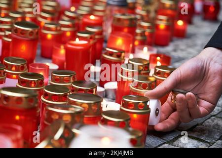 Una mano accende candele in occasione dell'anniversario della Rivoluzione di velluto il 17th novembre a Praga, in Cechia Foto Stock