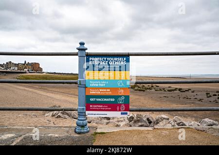 Avviso di precauzione di Covid allegato alle ringhiere sul lungomare Foto Stock