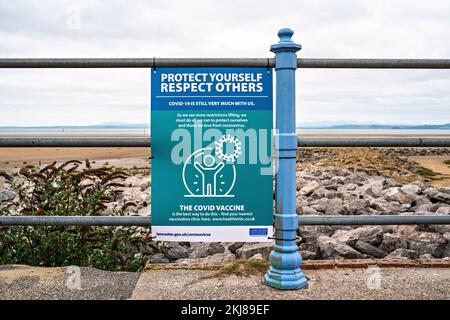 Avviso di precauzione di Covid allegato alle ringhiere sul lungomare Foto Stock