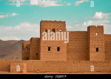 La Kasbah di Tannougalt in Marocco sotto un cielo nuvoloso blu Foto Stock