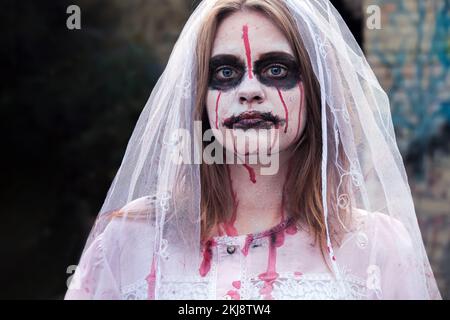 Strana donna in nero homburg trilby cappello e camicia, baffi e falsa barba  che regge telefono antico con cavo rotto su bianco Foto stock - Alamy