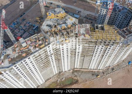 Vista aerea dall'alto di alti edifici residenziali in costruzione e gru Foto Stock