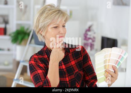 donna che guarda la tabella di vernice in una nuova cucina Foto Stock