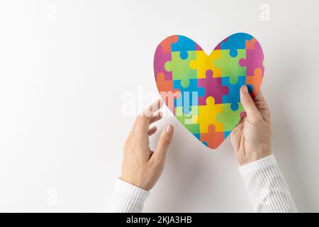 Composizione di mani che tengono il cuore puzzle puzzle jigsaw su sfondo bianco con spazio copia Foto Stock