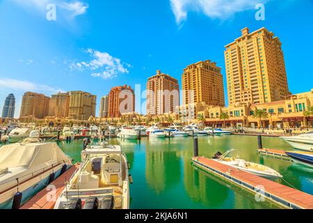Doha, Qatar - 18 febbraio 2019: Passeggiata Marina Corniche a Porto Arabia al Pearl-Qatar con torri residenziali e barche di lusso e yacht in Foto Stock