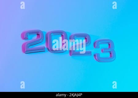 I numeri 2023 in luce al neon. Capodanno 2023 su sfondo rosa blu. La cartolina è in viola. Buon Natale. Foto Stock