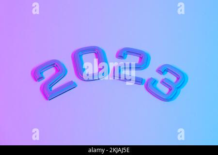 I numeri 2023 in luce al neon. Capodanno 2023 su sfondo rosa blu. La cartolina è in viola. Buon Natale. Foto Stock