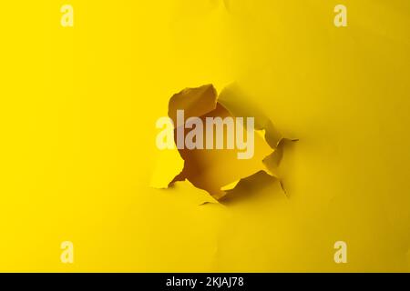Strappato un pezzo di carta gialla con spazio di copia su sfondo giallo Foto Stock