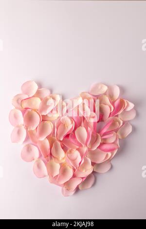 Vista dall'alto di petali rossi di rosa disposti a forma di cuore su sfondo  bianco con spazio per la copia Foto stock - Alamy