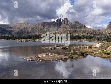 riva rocciosa sul lago elysia con mt geryon sullo sfondo del labirinto in culla lago di montagna parco nazionale di st clair della tasmania Foto Stock