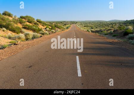 Mattina nel deserto con la strada alta vuota o la strada alta nazionale che passa attraverso il deserto. Orizzonte lontano, estate calda al deserto di Thar, Rajasthan, India. Foto Stock