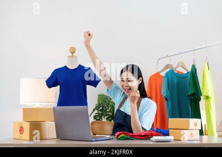 Felice eccitante donna asiatica di successo facendo business abbigliamento vendere online. utilizza un computer portatile. Vendita on-line di marketing consegna, PMI e Foto Stock