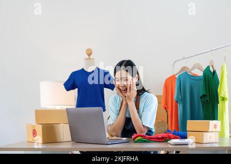 Felice eccitante donna asiatica di successo facendo business abbigliamento vendere online. utilizza un computer portatile. Vendita on-line di marketing consegna, PMI e Foto Stock