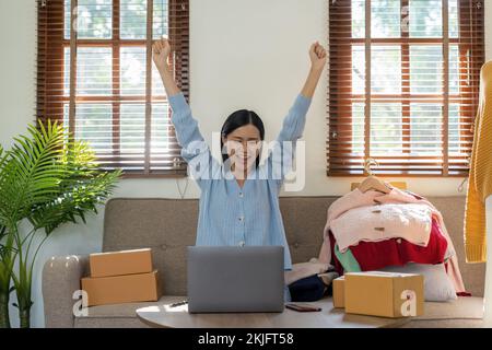 Felice eccitante donna asiatica di successo facendo business abbigliamento vendere online. utilizza un computer portatile. Vendita on-line di marketing consegna, PMI e Foto Stock