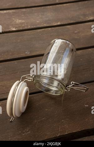 Vaso di vetro vuoto con guarnizione sottovuoto su tavole di legno di acacia Foto Stock