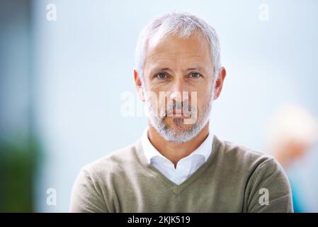 Lo prendo molto sul serio. Ritratto di un uomo d'affari maturo in piedi in un ufficio. Foto Stock