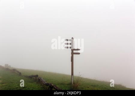 Indicazioni per sentieri escursionistici sulla cima della montagna Köterberg in nebbia, clima d'autunno squallida, Lügde, Weserbergland, Renania settentrionale-Vestfalia, Germania, Europa Foto Stock