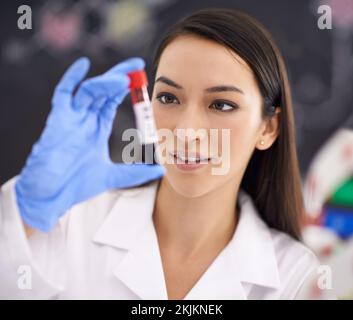 Far progredire la scienza medica. una scienziata femminile che tiene un campione di sangue. Foto Stock