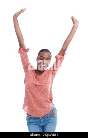 Im il vincitore. Studio shot di una giovane donna con le braccia alzate in festa. Foto Stock