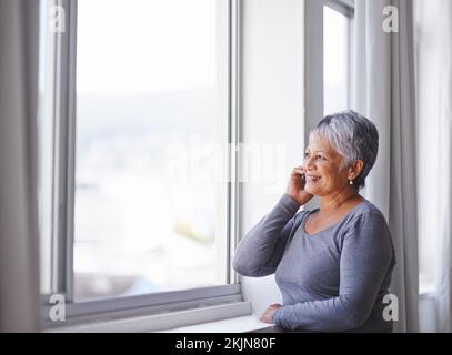 Goditi la vista. una donna matura che usa il cellulare a casa. Foto Stock