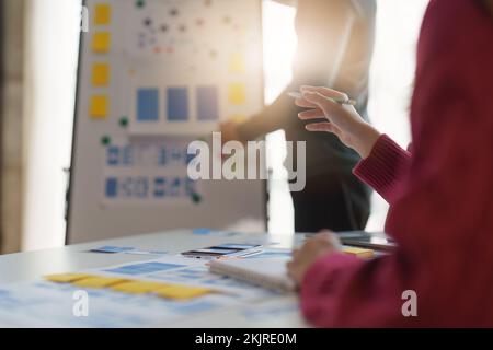 Gruppo di interfacce utente UX o progettisti che lavorano per creare contenuti di applicazioni mobili. Concetto di agenzia di sviluppo digitale creativo Foto Stock