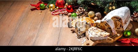 Tradizionale dressner stollencake di Natale con frutta secca, spezie, albero di Natale e decorazione su sfondo rustico in legno Foto Stock