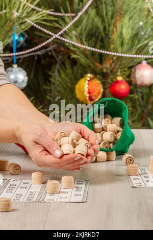 Mani di donna che tengono barili di legno per una partita in lotto Foto Stock