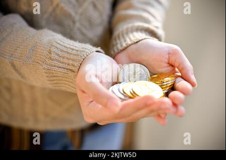 Le mani di una donna che tiene bitcoins d'oro e d'argento. immagine ravvicinata, investimento, risparmio di denaro, concetto finanziario Foto Stock