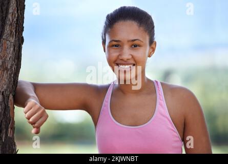 Fitness, ritratto e donna nera in natura per rilassarsi su un albero dopo esercizio fisico, allenamento o allenamento in estate. Parco, sport e ragazza sana Foto Stock