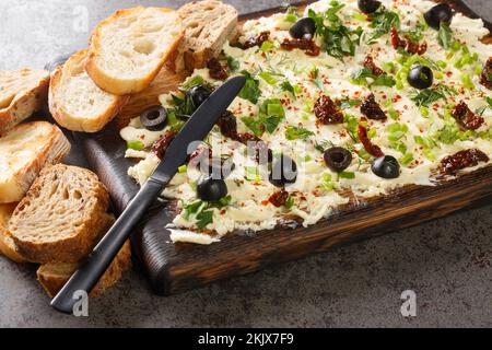 Gustoso panino con erbe fresche, olive, pomodori secchi serviti con il primo piano del pane su sfondo scuro. Orizzontale Foto Stock