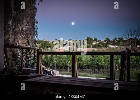 Vista dal vecchio fienile dei vitigni si trovano a maturare le uve nella campagna francese illuminata dalla luna prima della vendemmia per la produzione di vino Foto Stock