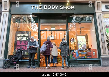 New Street, Birmingham 25 novembre 2022. Un uomo aspetta fuori dal Body Shop nel centro di Birmingham mentre la sua famiglia guarda gli affari all'interno del Black Friday. Foto di credito: Stop Press MediaAlamy Live News Foto Stock