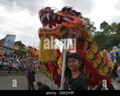 La danza del drago tipica della Cina è suonata da bambini indonesiani Foto Stock