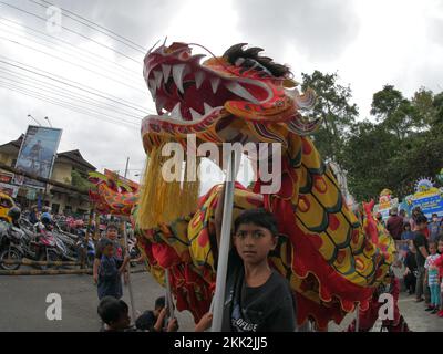 La danza del drago tipica della Cina è suonata da bambini indonesiani Foto Stock