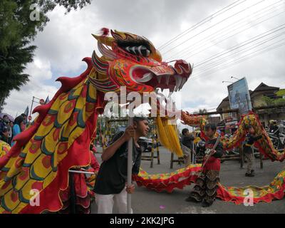 La danza del drago tipica della Cina è suonata da bambini indonesiani Foto Stock