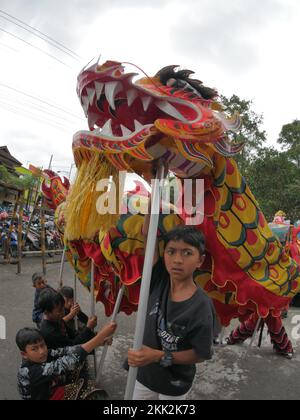 La danza del drago tipica della Cina è suonata da bambini indonesiani Foto Stock