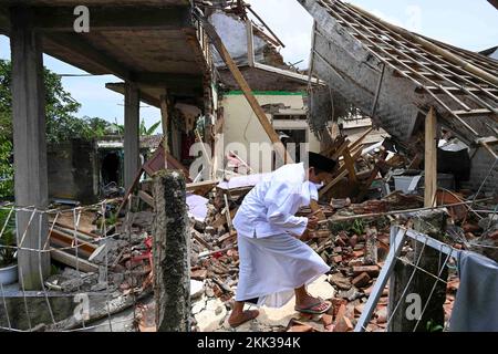 Cianjur, Indonesia. 25th Nov 2022. Un uomo passa davanti a una casa danneggiata dopo aver partecipato alla preghiera del venerdì in un villaggio sismico a Cianjur, Giava Occidentale, Indonesia, 25 novembre 2022. Il bilancio delle vittime del terremoto di magnitudo 5,6 che ha colpito la provincia indonesiana di Giava occidentale è aumentato a 310, e altri 24 erano ancora mancanti, ha detto un funzionario il venerdì. Credit: Zulkarnain/Xinhua/Alamy Live News Foto Stock