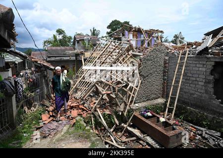 Cianjur, Indonesia. 25th Nov 2022. La gente passa davanti alle case danneggiate dopo aver partecipato alla preghiera del venerdì in un villaggio sismico a Cianjur, Giava Occidentale, Indonesia, 25 novembre 2022. Il bilancio delle vittime del terremoto di magnitudo 5,6 che ha colpito la provincia indonesiana di Giava occidentale è aumentato a 310, e altri 24 erano ancora mancanti, ha detto un funzionario il venerdì. Credit: Zulkarnain/Xinhua/Alamy Live News Foto Stock