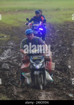 Cianjur, Indonesia. 25th Nov 2022. Un uomo trasporta aiuti alimentari in moto a Cianjur, Giava Occidentale, Indonesia, 25 novembre 2022. Il bilancio delle vittime del terremoto di magnitudo 5,6 che ha colpito la provincia indonesiana di Giava occidentale è aumentato a 310, e altri 24 erano ancora mancanti, ha detto un funzionario il venerdì. Credit: Zulkarnain/Xinhua/Alamy Live News Foto Stock