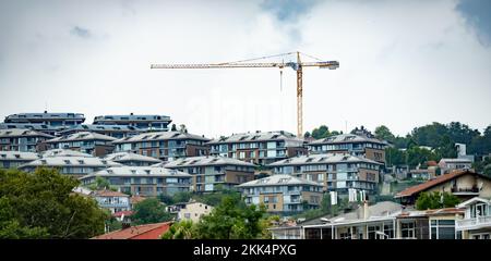 Una vista panoramica degli edifici residenziali e di una gru sotto un cielo nuvoloso alla luce del giorno Foto Stock