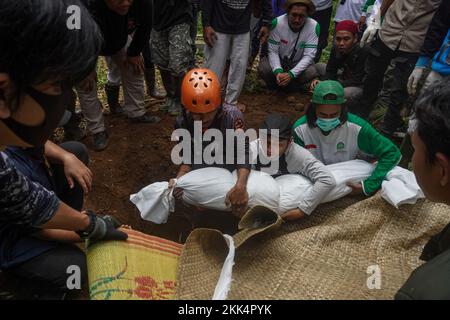 Cianjur, Giava Occidentale, Indonesia. 25th Nov 2022. La gente seppellisce il corpo di 7 anni Asika Nur Fauziah, che è sepolto in rovine a seguito del terremoto di magnitudo 5,6 che è accaduto nel distretto di Cugenang, Cianjur, Giava Occidentale, Indonesia, al cimitero il 21 novembre 2022. (Credit Image: © Dicky Bisinglasi/ZUMA Press Wire) Foto Stock