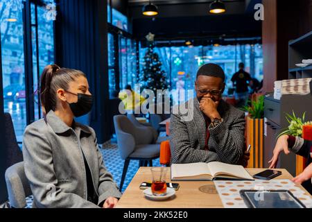 Gruppo di persone affariste multirazziali stanno ridendo e sedendosi Foto Stock