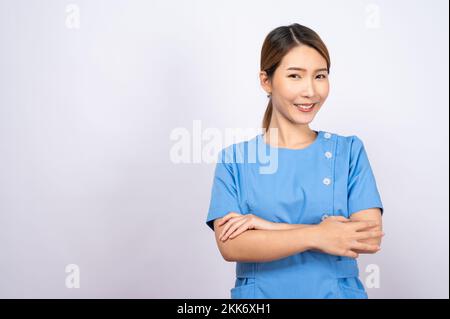 Un ritratto di una giovane infermiera asiatica su sfondo bianco Foto Stock